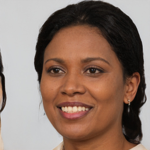 Joyful black adult female with medium  black hair and brown eyes