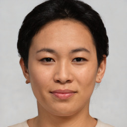 Joyful asian young-adult female with short  black hair and brown eyes