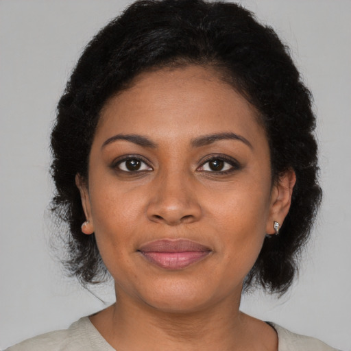 Joyful black young-adult female with medium  brown hair and brown eyes