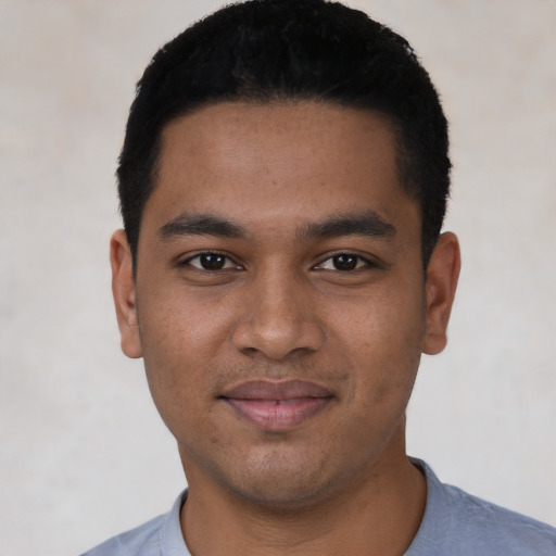 Joyful black young-adult male with short  black hair and brown eyes