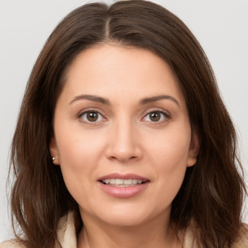 Joyful white young-adult female with long  brown hair and brown eyes