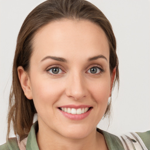 Joyful white young-adult female with medium  brown hair and grey eyes