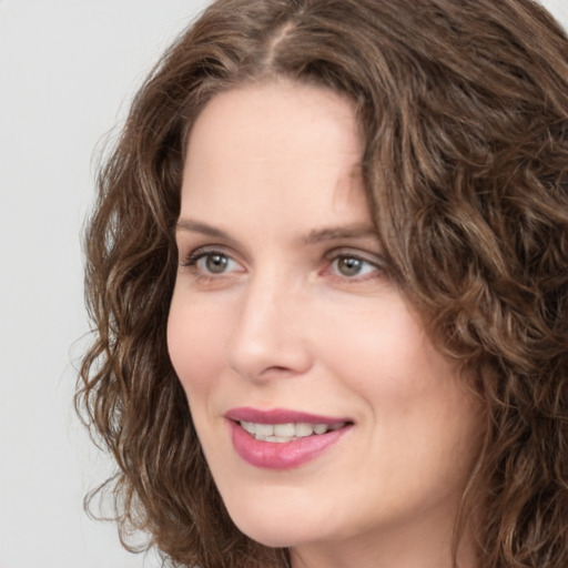 Joyful white young-adult female with long  brown hair and green eyes