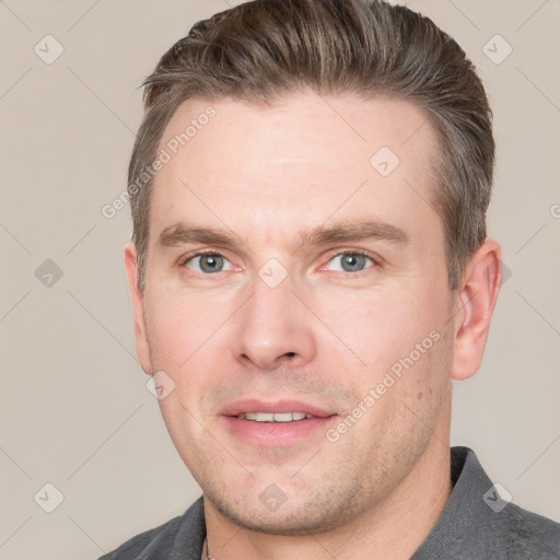 Joyful white young-adult male with short  brown hair and grey eyes