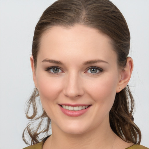 Joyful white young-adult female with medium  brown hair and grey eyes