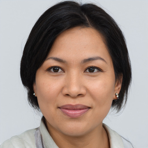 Joyful asian adult female with medium  brown hair and brown eyes