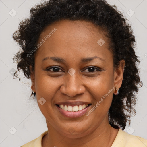 Joyful black adult female with long  brown hair and brown eyes