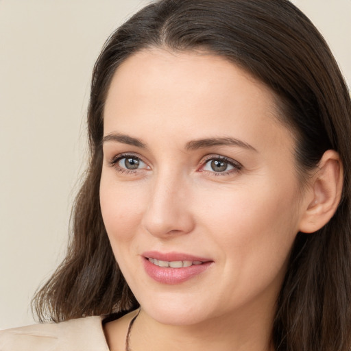 Joyful white young-adult female with long  brown hair and brown eyes