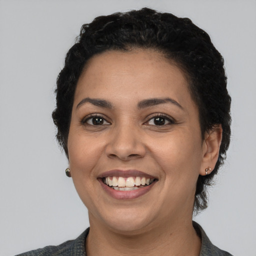 Joyful latino young-adult female with short  black hair and brown eyes