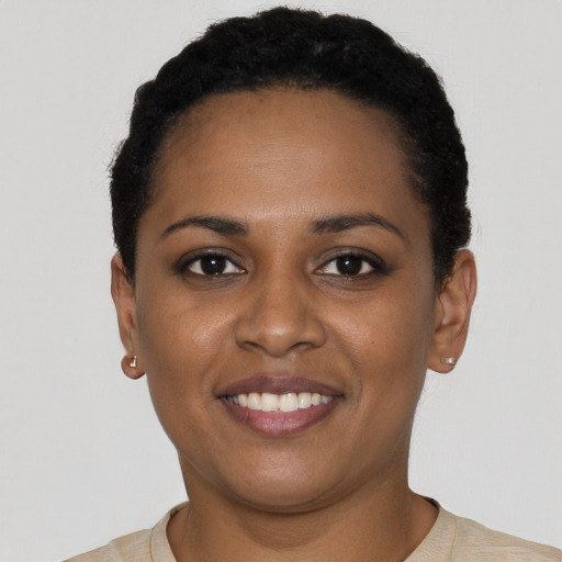 Joyful black young-adult female with short  black hair and brown eyes