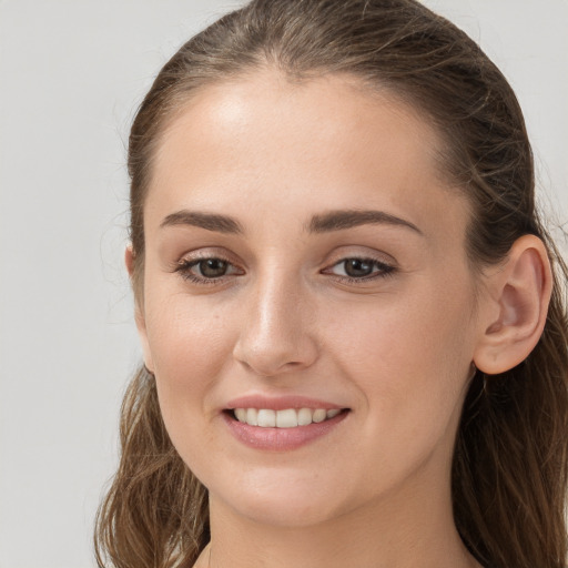 Joyful white young-adult female with long  brown hair and grey eyes