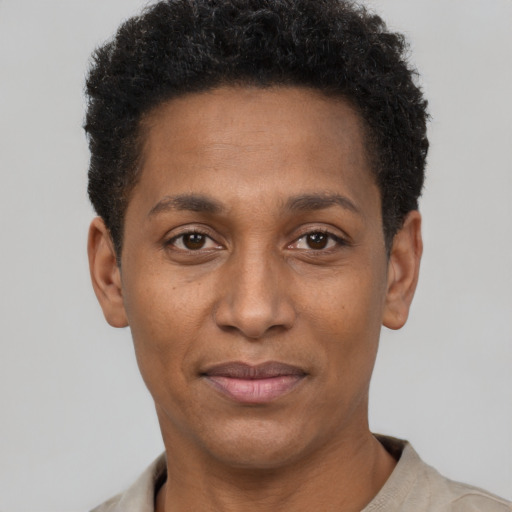Joyful black young-adult male with short  brown hair and brown eyes