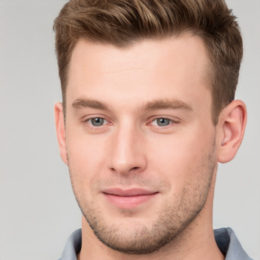 Joyful white young-adult male with short  brown hair and grey eyes