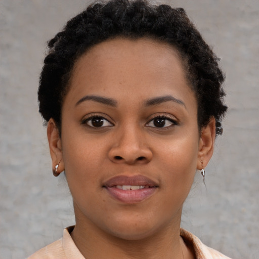 Joyful black young-adult female with short  brown hair and brown eyes