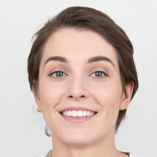 Joyful white young-adult female with short  brown hair and grey eyes