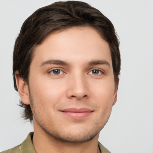 Joyful white young-adult male with short  brown hair and grey eyes