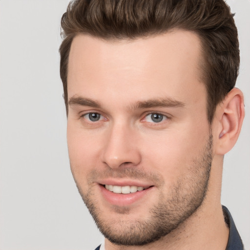 Joyful white young-adult male with short  brown hair and brown eyes