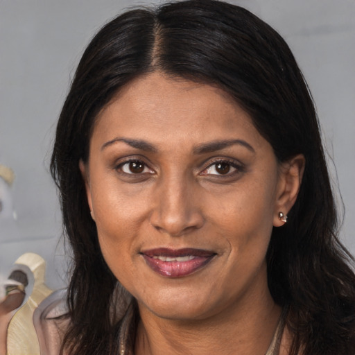 Joyful latino adult female with long  brown hair and brown eyes