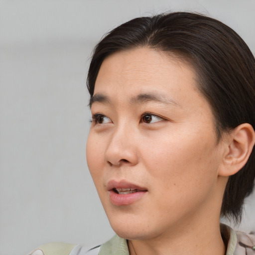 Joyful asian young-adult female with medium  brown hair and brown eyes