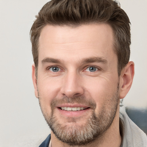 Joyful white adult male with short  brown hair and grey eyes