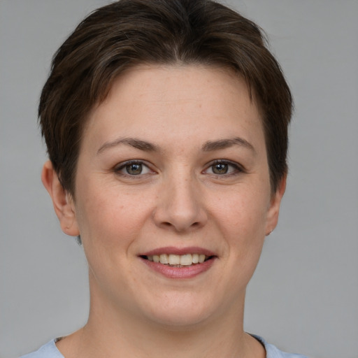 Joyful white young-adult female with short  brown hair and grey eyes