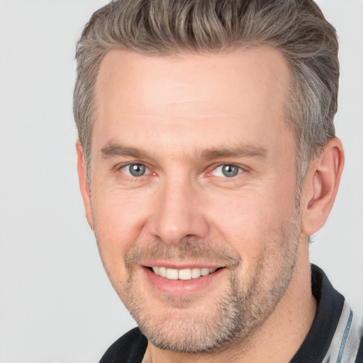 Joyful white adult male with short  brown hair and brown eyes