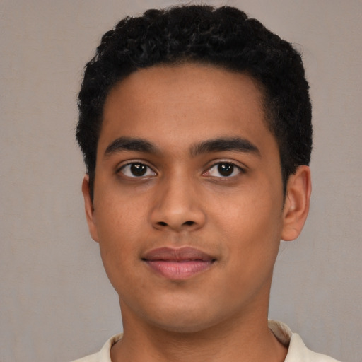 Joyful latino young-adult male with short  brown hair and brown eyes