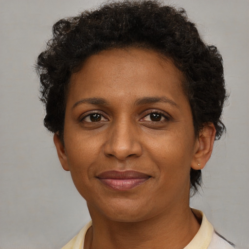 Joyful black adult female with short  brown hair and brown eyes