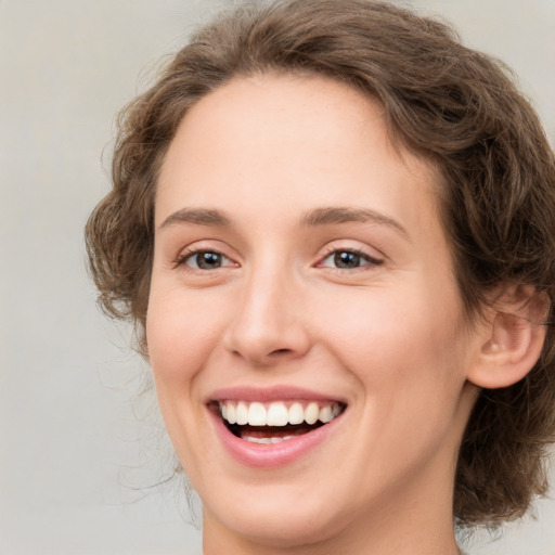 Joyful white young-adult female with medium  brown hair and green eyes