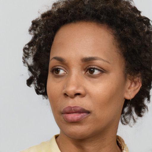 Neutral black young-adult female with medium  brown hair and brown eyes
