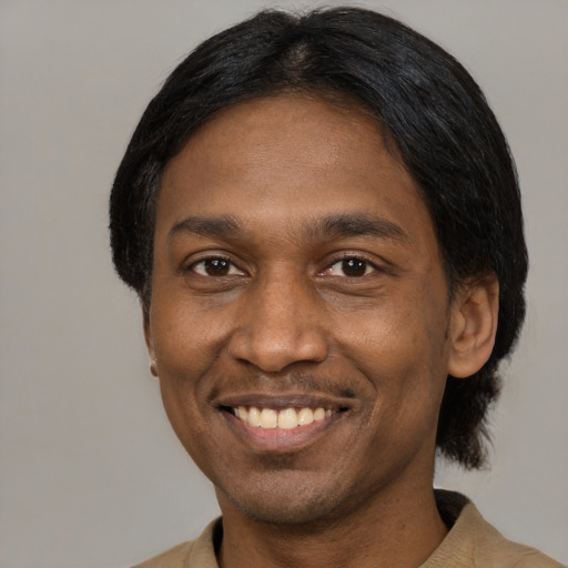Joyful black adult male with short  black hair and brown eyes