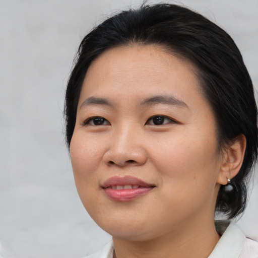 Joyful asian young-adult female with medium  brown hair and brown eyes