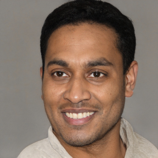 Joyful latino young-adult male with short  black hair and brown eyes