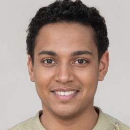 Joyful latino young-adult male with short  brown hair and brown eyes