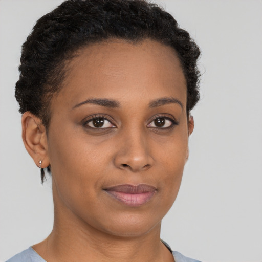 Joyful black young-adult female with short  brown hair and brown eyes