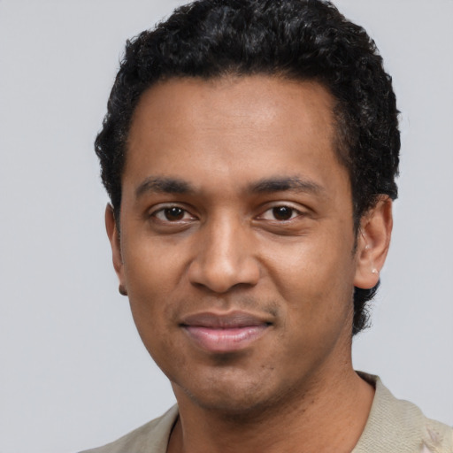 Joyful black young-adult male with short  black hair and brown eyes