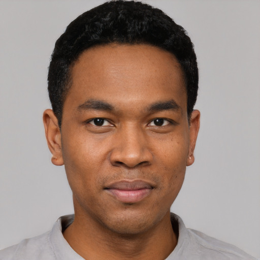 Joyful black young-adult male with short  black hair and brown eyes