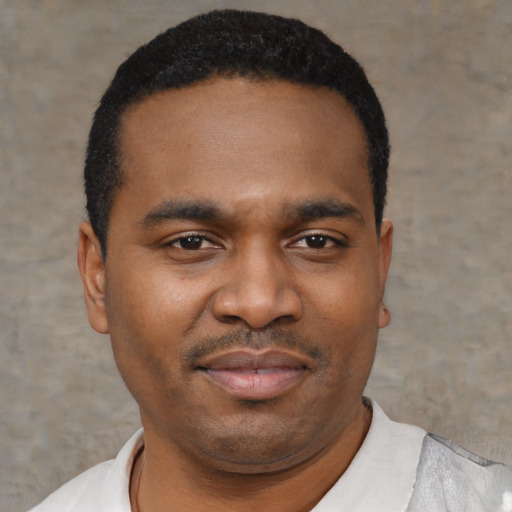 Joyful black young-adult male with short  black hair and brown eyes