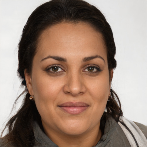 Joyful latino adult female with long  brown hair and brown eyes