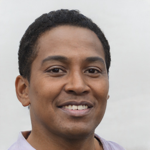 Joyful black young-adult male with short  brown hair and brown eyes