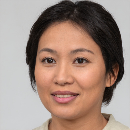 Joyful asian young-adult female with medium  brown hair and brown eyes