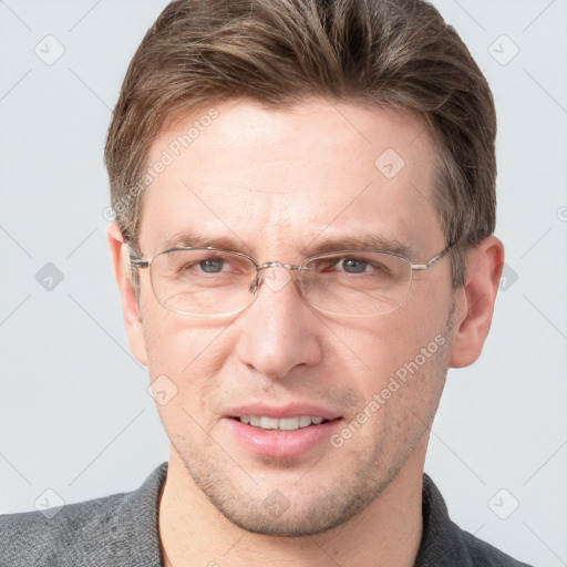 Joyful white adult male with short  brown hair and grey eyes