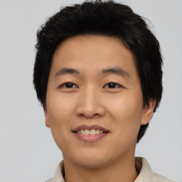 Joyful asian young-adult male with short  brown hair and brown eyes