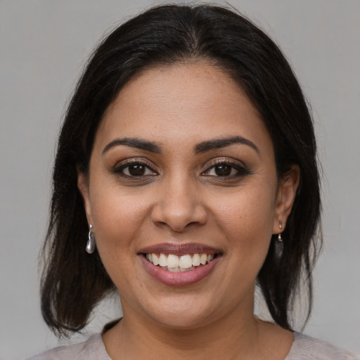 Joyful latino young-adult female with medium  brown hair and brown eyes
