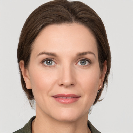 Joyful white young-adult female with medium  brown hair and grey eyes