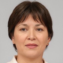 Joyful white adult female with medium  brown hair and brown eyes