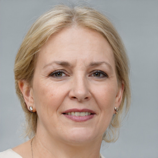 Joyful white adult female with medium  blond hair and grey eyes