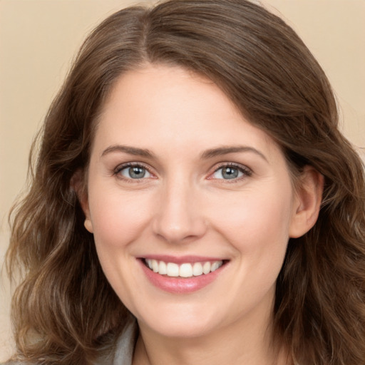 Joyful white young-adult female with long  brown hair and grey eyes