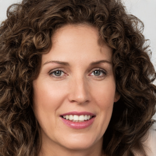 Joyful white young-adult female with medium  brown hair and green eyes