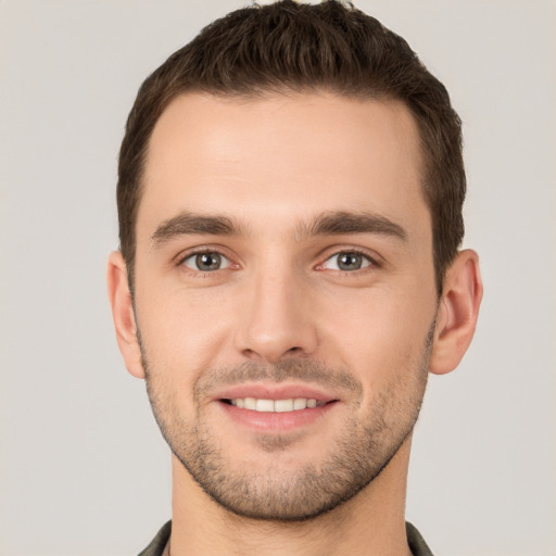 Joyful white young-adult male with short  brown hair and grey eyes